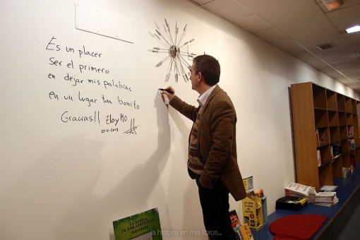 Santiago firmando en la pared de autores de Librería Birdy